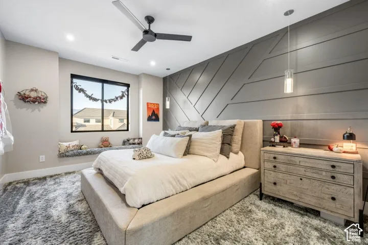 Accent wall with geometric paneling, recessed lighting, and a modern ceiling fan
