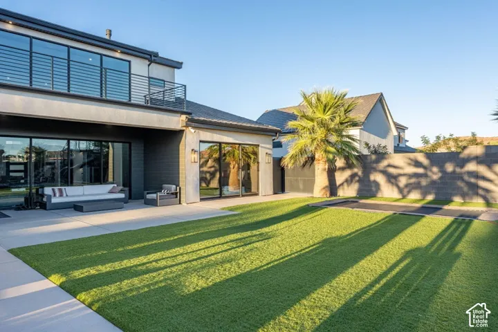 Expansive patio with direct access to interior spaces, featuring a modern exterior with large windows and a second-story balcony