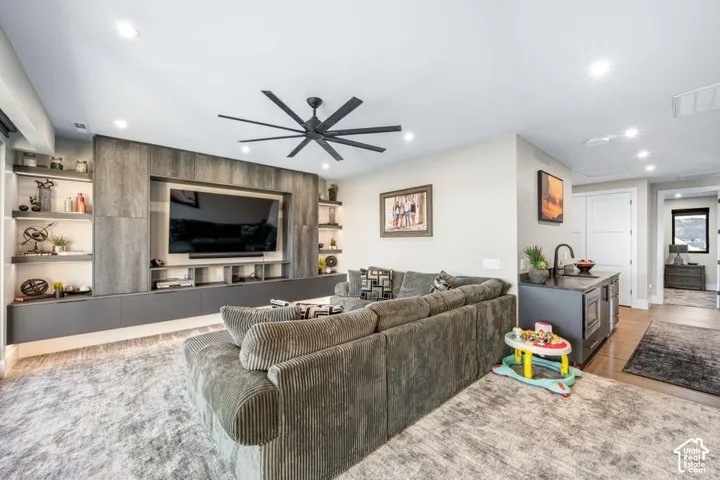 Open-concept living space anchored by a custom wood-finish entertainment wall with integrated shelving and media nook