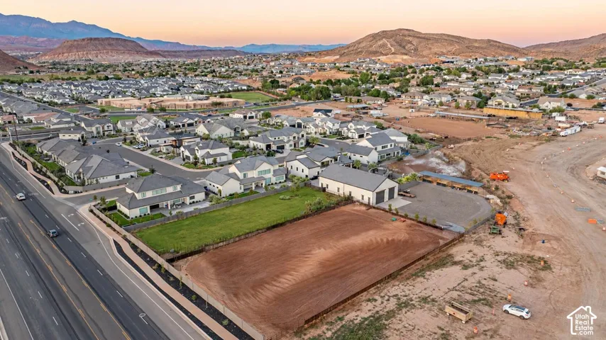 Expansive lot with substantial frontage, featuring a partially graded surface and a perimeter fence