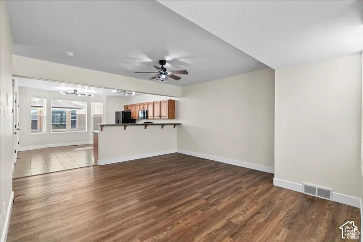 Spacious interior featuring wood-finish flooring, a ceiling fan, and recessed lighting