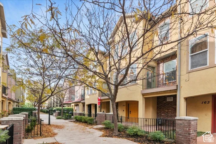 Stucco exterior with brick accents and multiple balconies with metal railings