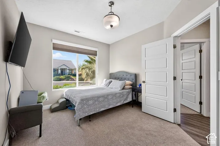 Carpeted room with a ceiling-mounted light fixture, white five-panel interior doors, and a large window