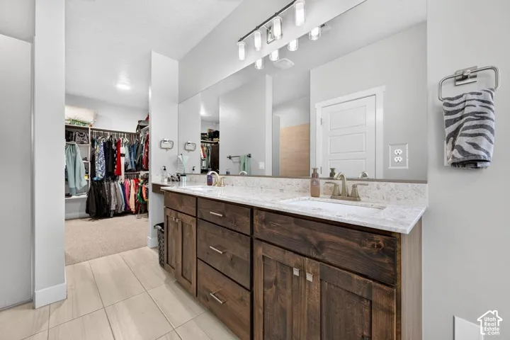 Double vanity with wood-finish cabinetry and light-toned countertops