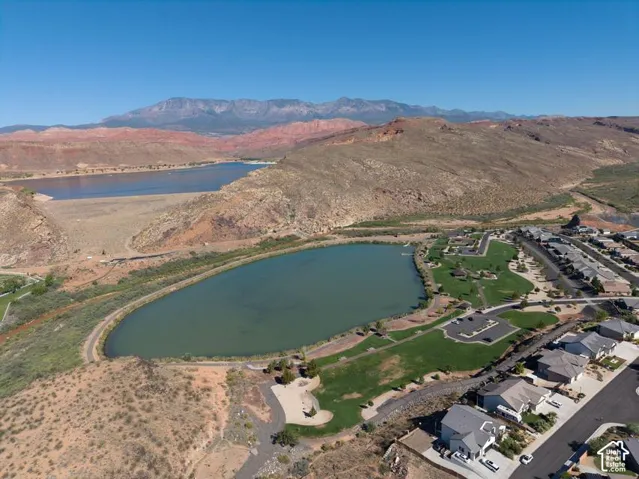 Expansive residential area with a prominent lake, surrounded by natural terrain and distant mountains
