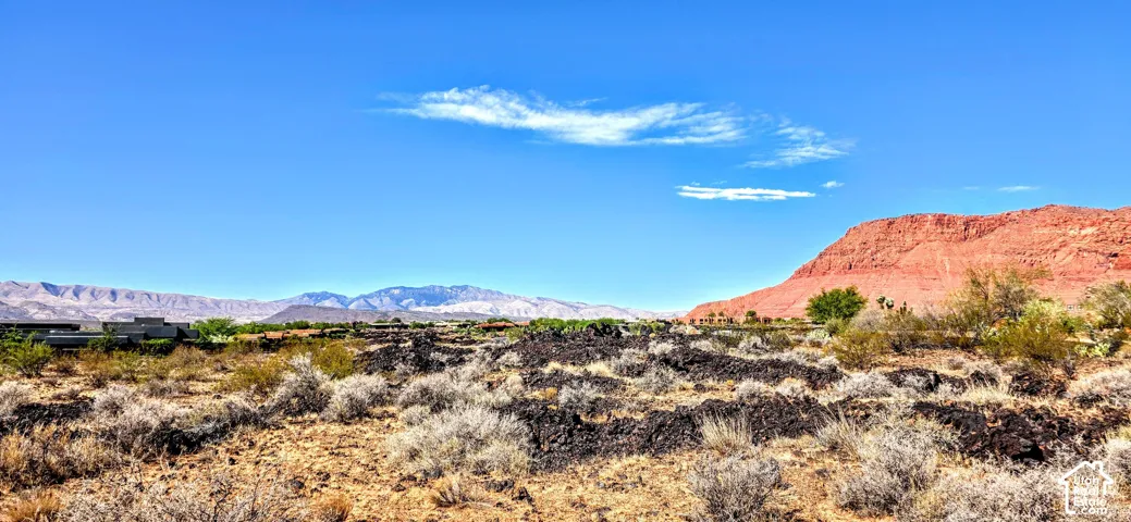 Expansive desert landscape featuring natural rock formations and distant mountain ranges