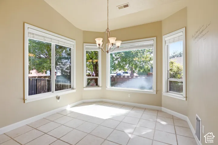 Tiled flooring, multiple large windows, and a ceiling-mounted light fixture