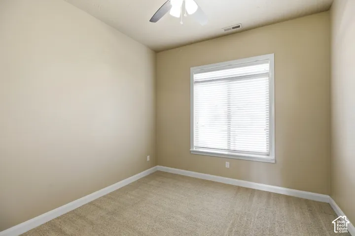 Neutral-toned carpeting, light-colored walls, and a window with blinds
