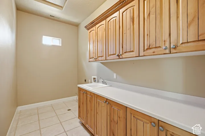 Extensive upper and lower cabinetry with wood-finish doors, integrated sink, and light-toned countertop