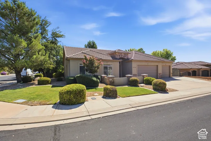 Single-story residence featuring a tile roof, stucco exterior, and an attached two-car garage
