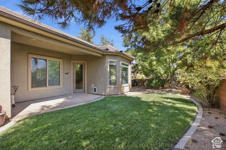 Covered patio space, bay windows, and a landscaped lawn