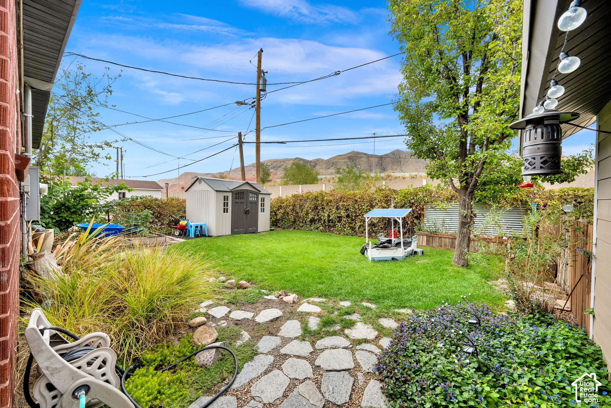 Expansive backyard featuring a manicured lawn, mature trees, and a stone pathway