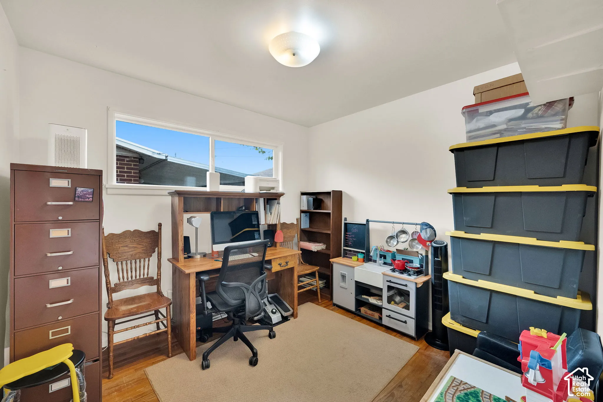 Room featuring a window, light-colored walls, and wood-finish flooring