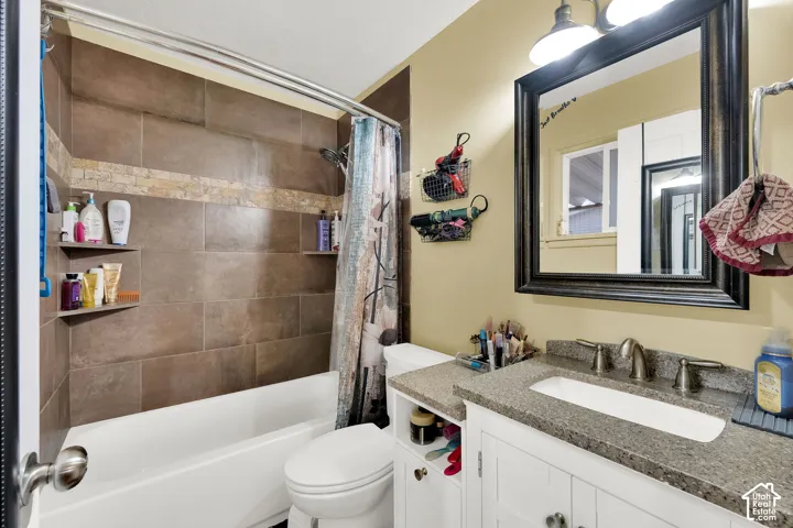 Tub-shower combination with brown tile surround and decorative tile band