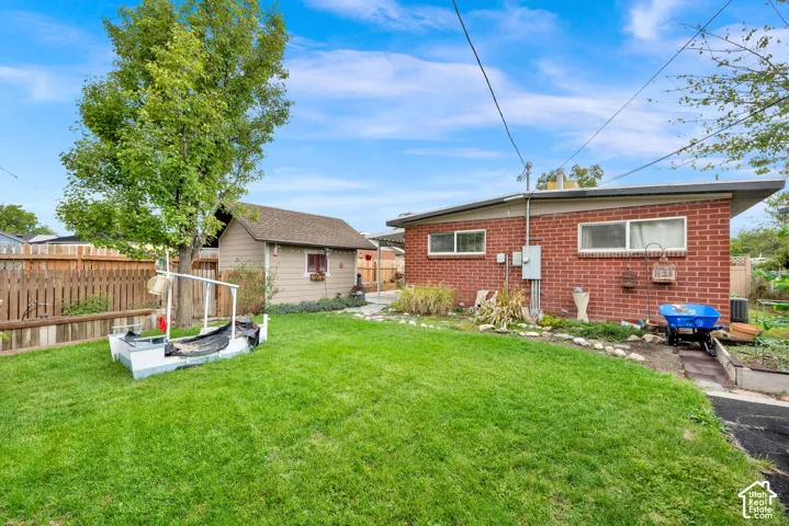 Expansive backyard featuring a meticulously manicured lawn, mature shade trees, and established landscaping beds