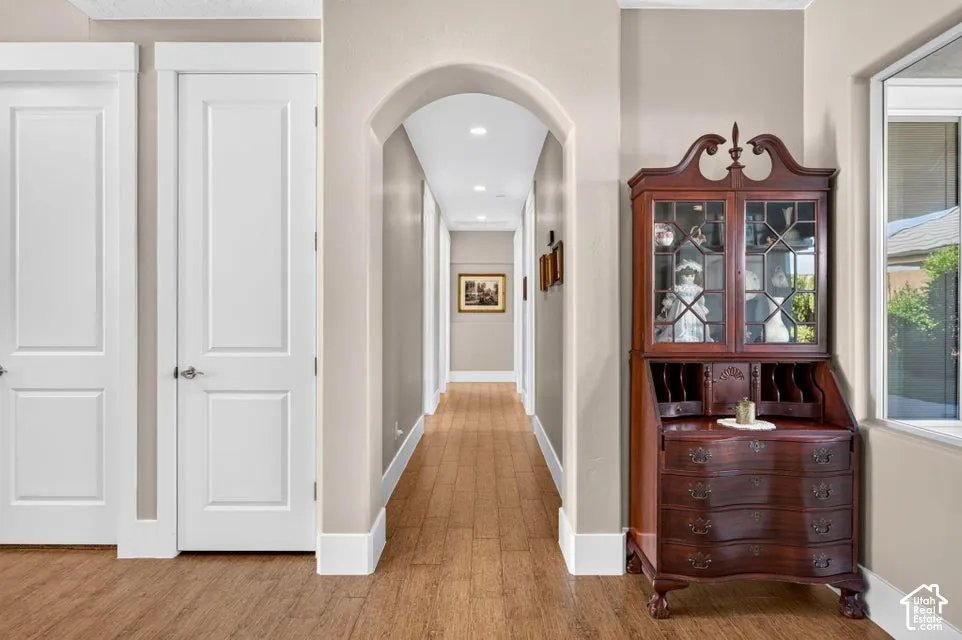 Arched entryway featuring recessed lighting and wood-finish flooring