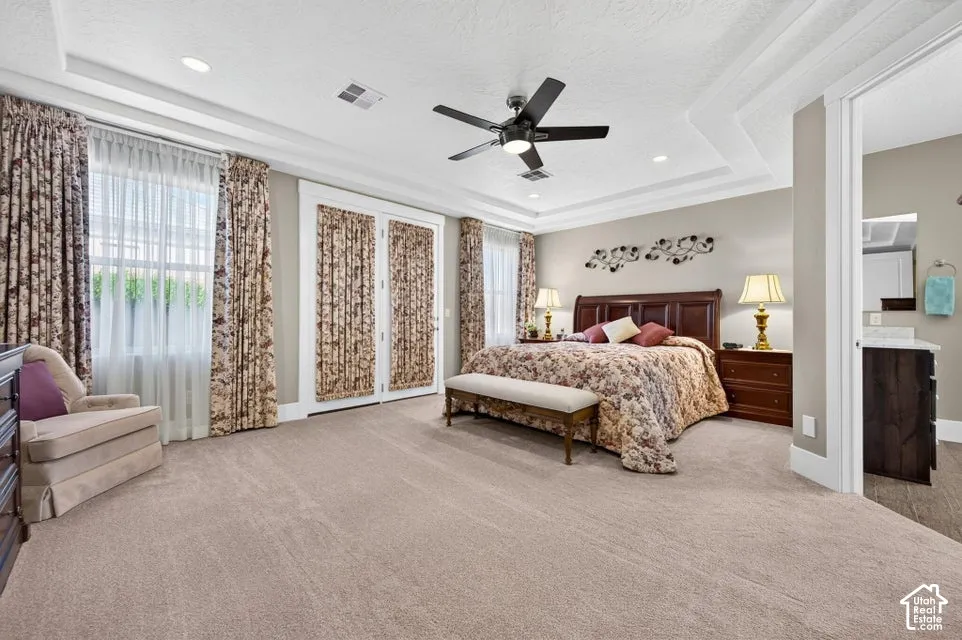 Recessed ceiling with crown molding, ceiling fan, and carpeted flooring
