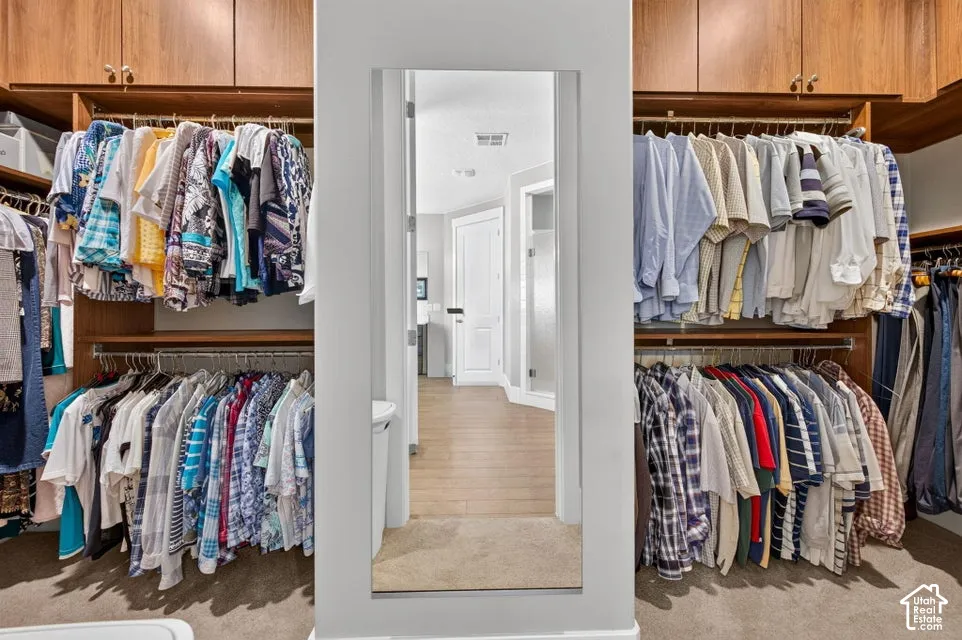 Custom closet system featuring built-in cabinetry, shelving, and multiple hanging rods
