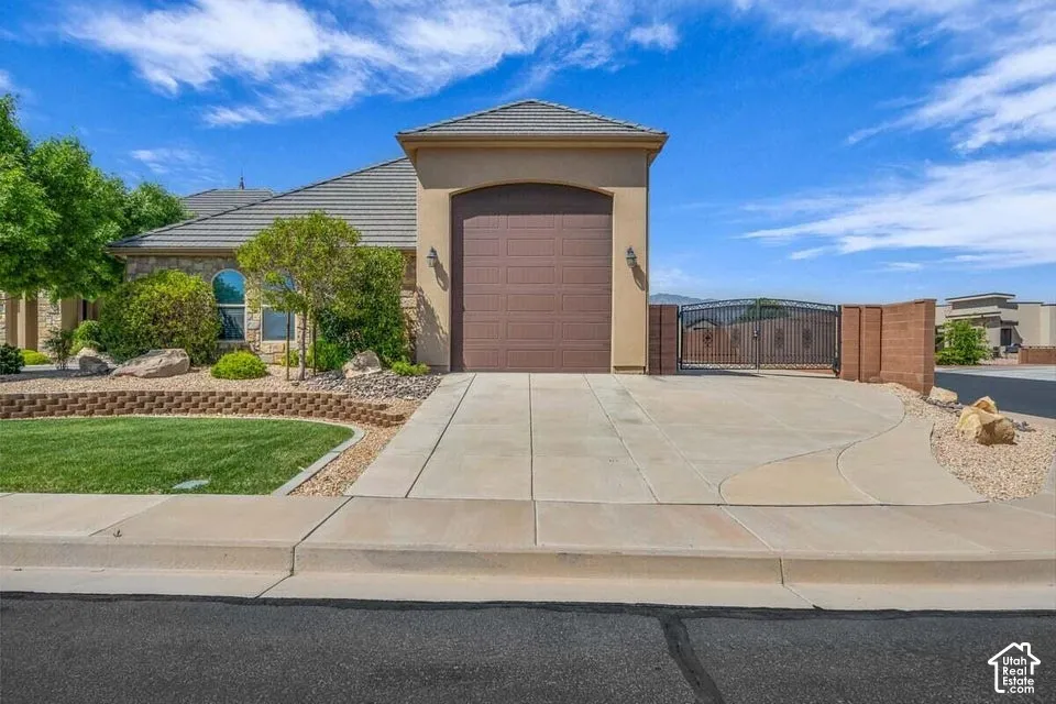 Stucco exterior with a tile roof, arched window, and attached garage