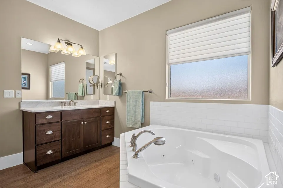 Wood-finish flooring with a dark wood vanity, a single basin, and a light-colored countertop