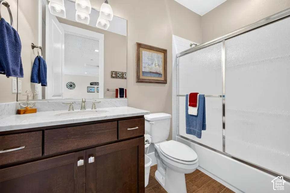 Bathroom featuring a dark wood-finish vanity with a white countertop, an undermount sink, and brushed nickel fixtures