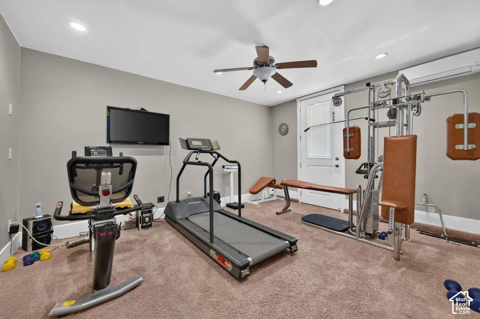 Recessed lighting illuminating the room, ceiling fan, and light tan carpeting