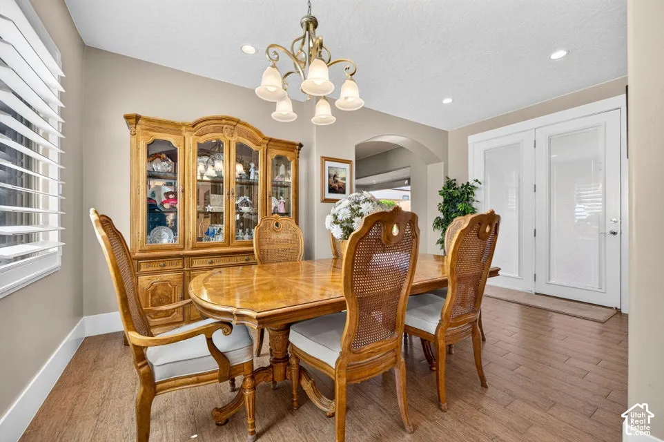 Recessed lighting, arched doorway, and wood-finish flooring