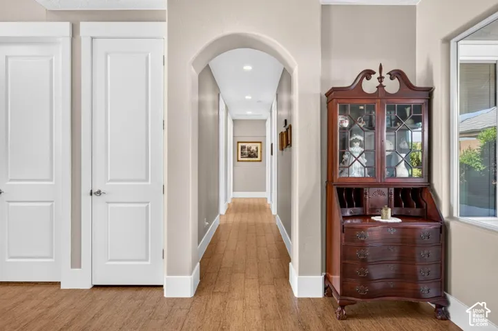 Arched entryway featuring recessed lighting and wood-finish flooring