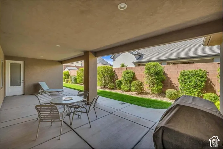 Covered patio with recessed lighting, concrete flooring, and an exterior door