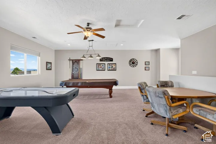Expansive recreation room featuring carpeting, a ceiling fan, and recessed lighting