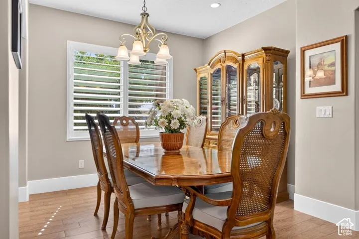 Recessed lighting, wood-finish flooring, white baseboards, and window with plantation shutters