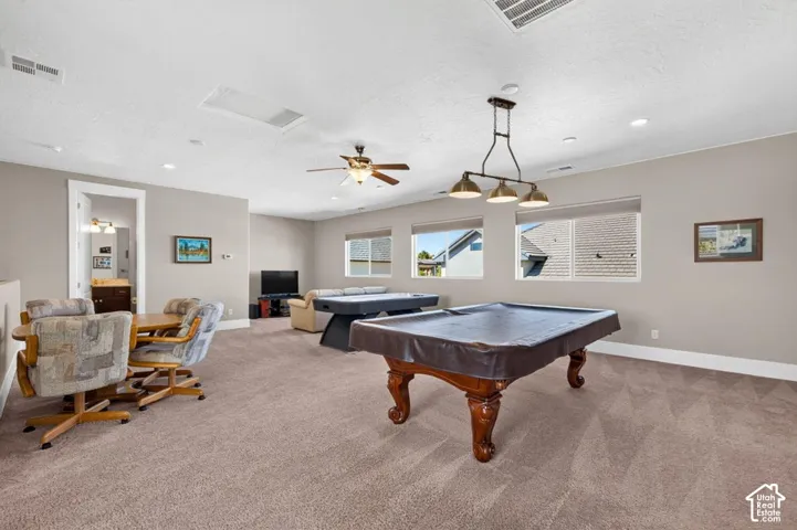 Spacious bonus room featuring neutral carpeting, recessed lighting, ceiling fan, and multiple windows