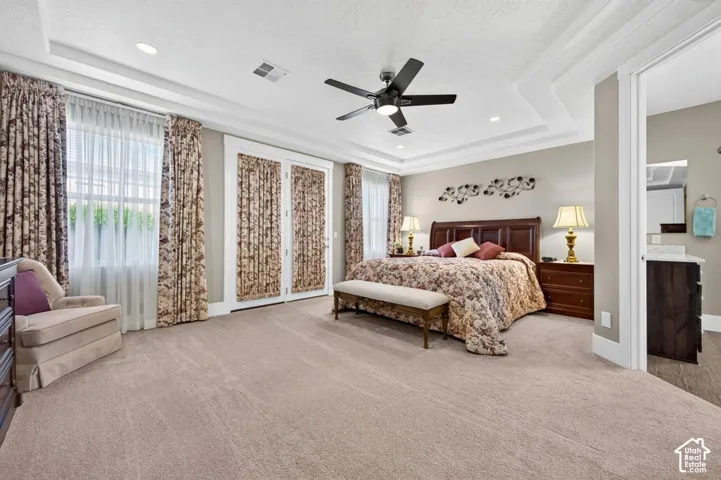 Recessed ceiling with crown molding, ceiling fan, and carpeted flooring