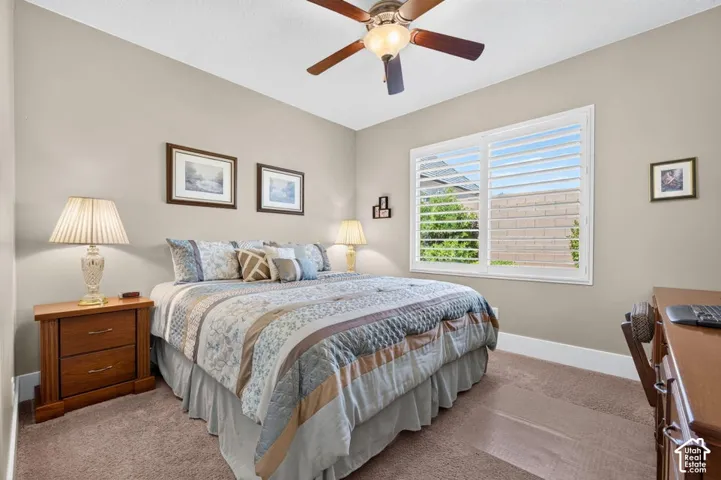 Recessed lighting with a ceiling fan, neutral wall color, white window frame with louvered shutters, and carpet flooring