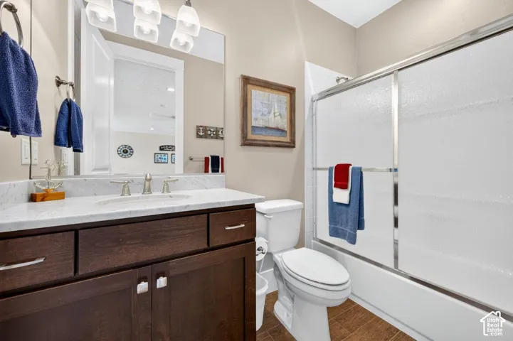 Bathroom featuring a dark wood-finish vanity with a white countertop, an undermount sink, and brushed nickel fixtures