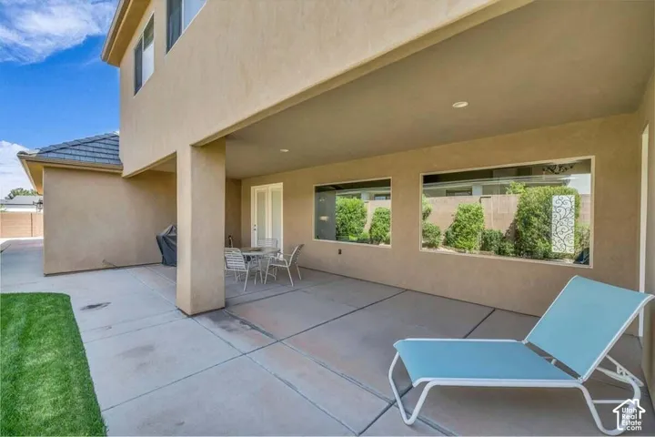 Covered patio with a stucco exterior, concrete flooring, and recessed lighting