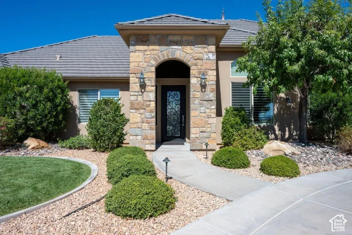 Stone facade entry with an arched doorway and decorative iron-detailed front door