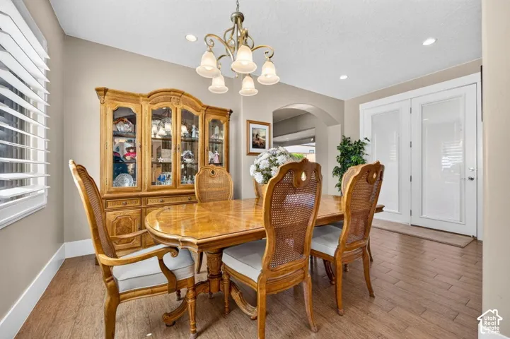 Recessed lighting, arched doorway, and wood-finish flooring