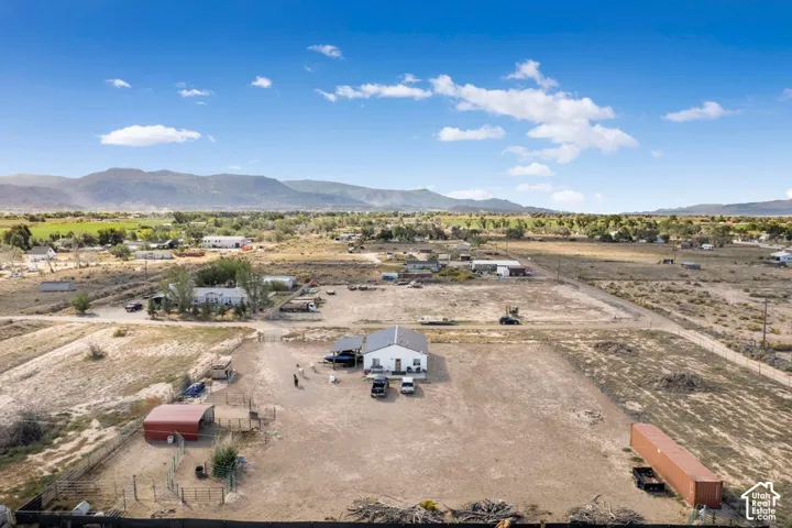 Single-story white dwelling with a dark roof and an expansive dirt lot