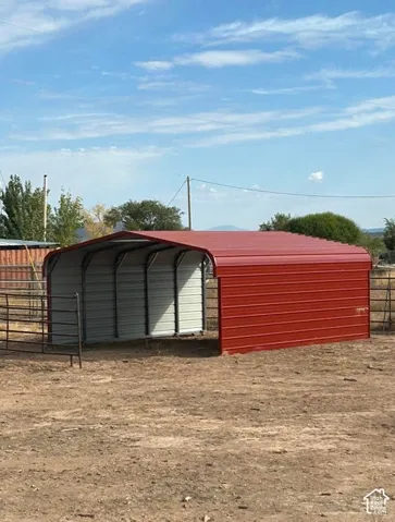 Red metal carport with rounded roof and corrugated sides
