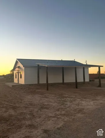 White siding exterior with a metal roof
