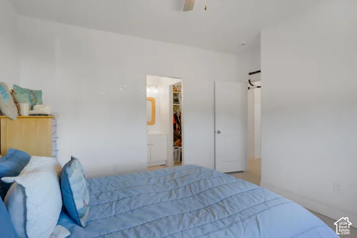 Bright bedroom featuring blue bedding, soft white walls, and ample natural light