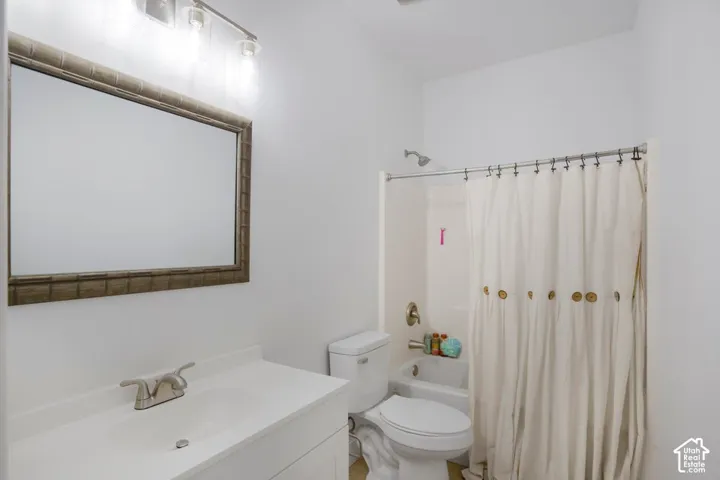 Vanity with integrated sink, brushed nickel faucet, framed mirror, and bathtub with shower