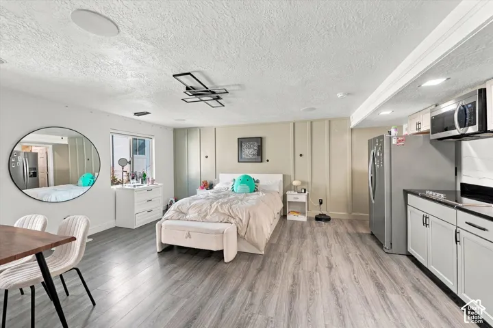 Wood-finish flooring throughout, with a recessed ceiling light and a contemporary chandelier