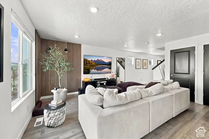 Wood-finish flooring, recessed lighting, and a slatted accent wall