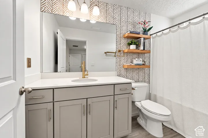 Vanity with a light gray cabinet, white countertop, and gold-finish faucet