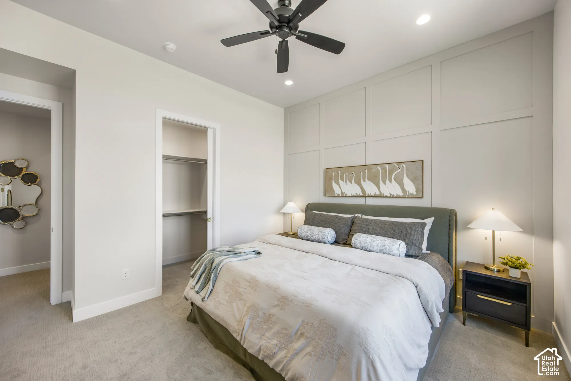 Recessed lighting, ceiling fan, accent wall with paneling, built-in closet shelving, and carpet flooring