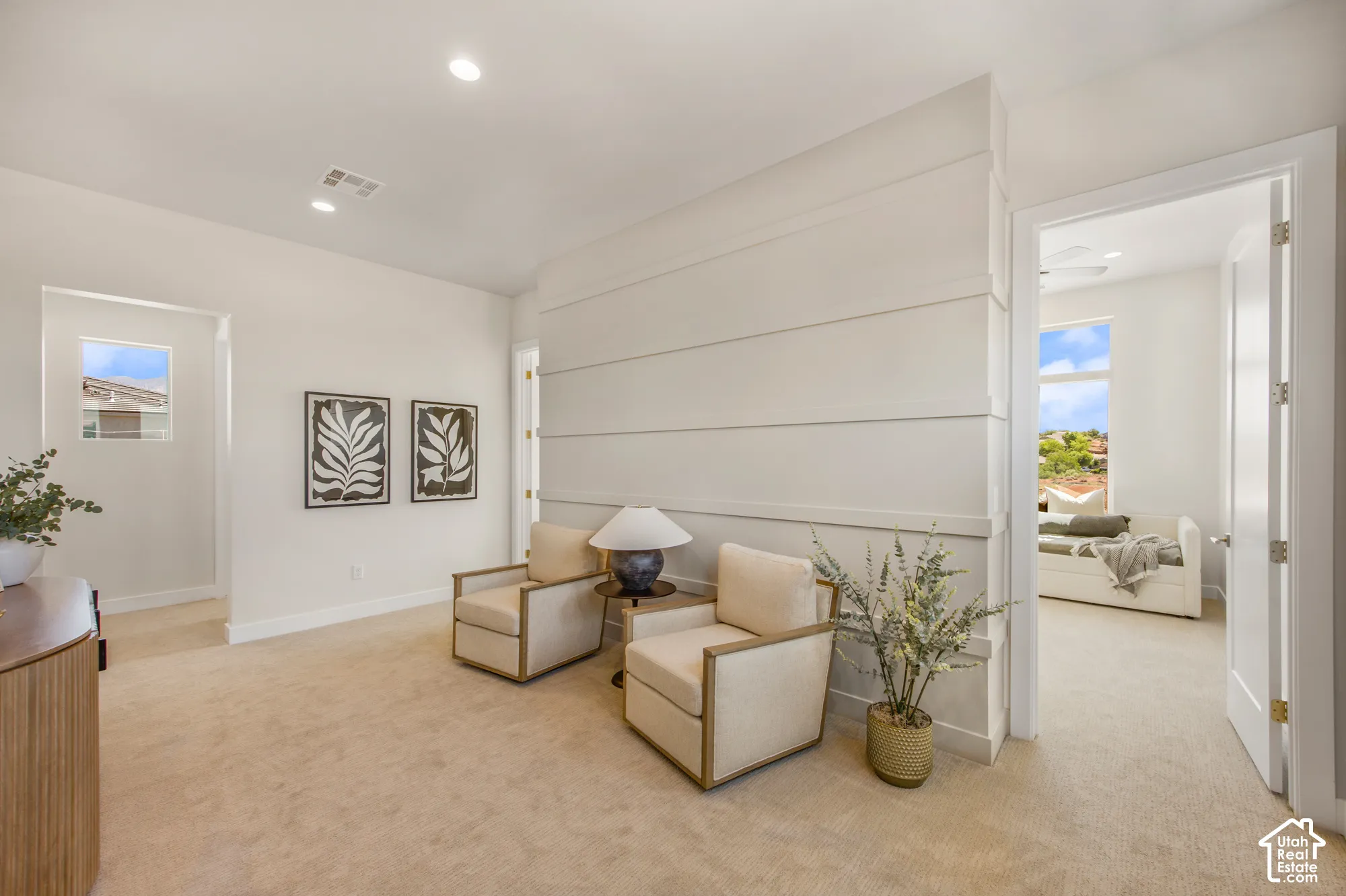 Recessed lighting illuminates the space, featuring a shiplap accent wall and plush carpeting