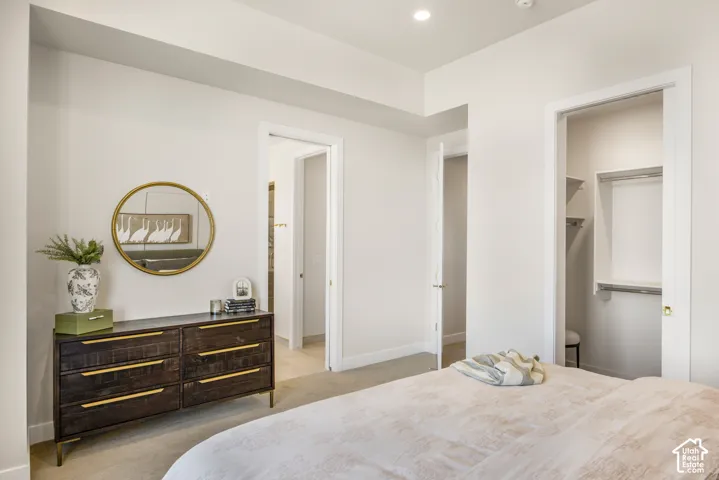 Recessed lighting, wall-to-wall carpeting, and a built-in closet with shelving