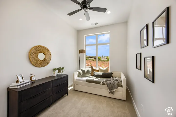 Neutral-toned wall paint, large window, carpet flooring, recessed lighting, and a ceiling fan